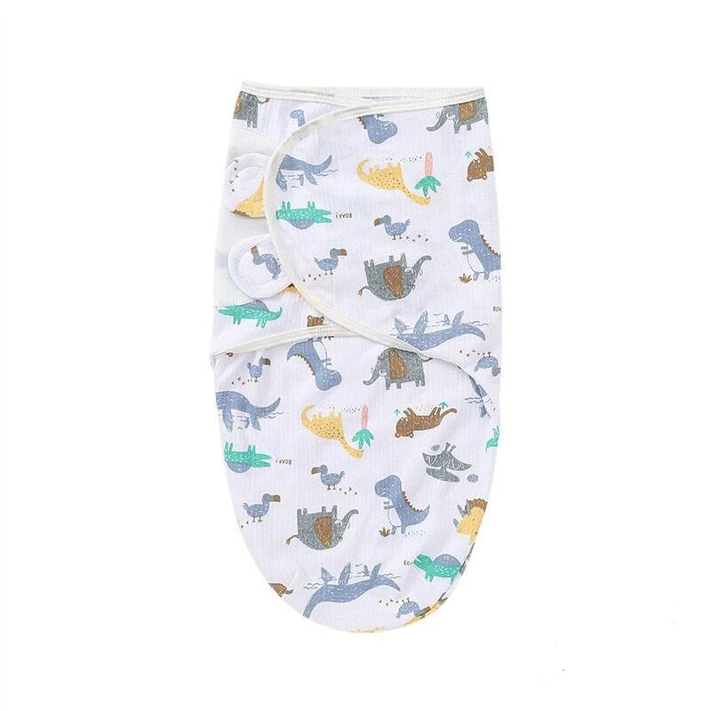 Nid d’ange bébé léger motif dinosaures colorés, tissu fin et respirant, forme enveloppante adaptée aux périodes estivales.