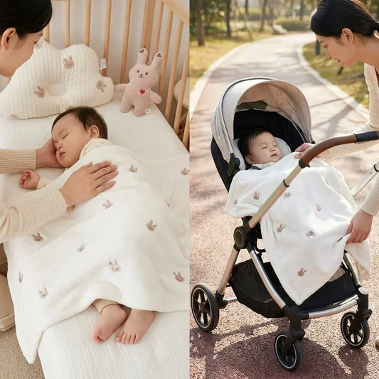 Maman couvrant son bébé avec une couverture polaire blanche motif lapins, utilisation polyvalente à la maison dans le berceau et en poussette à l’extérieur, texture douce et chaude adaptée à l’hiver.
