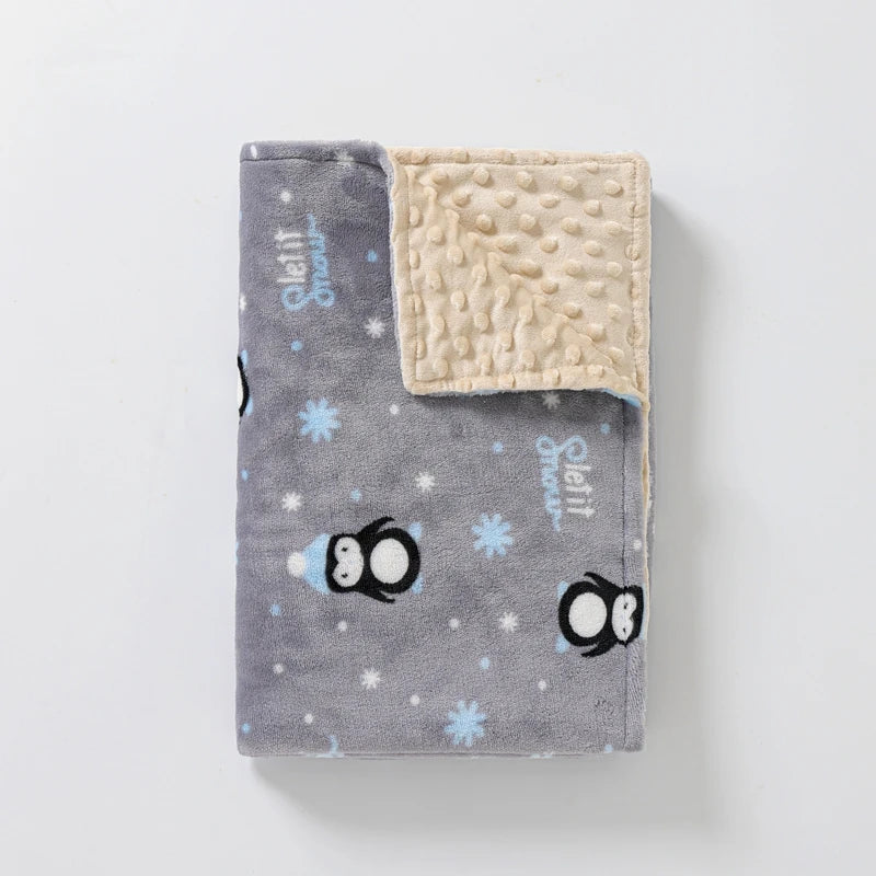 Couverture polaire bébé grise motif pingouins avec intérieur beige texturé, idéale pour garder bébé au chaud en hiver
