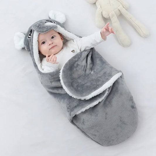 Nid d’ange bébé gris avec capuche éléphant ultra doux posé sur fond clair