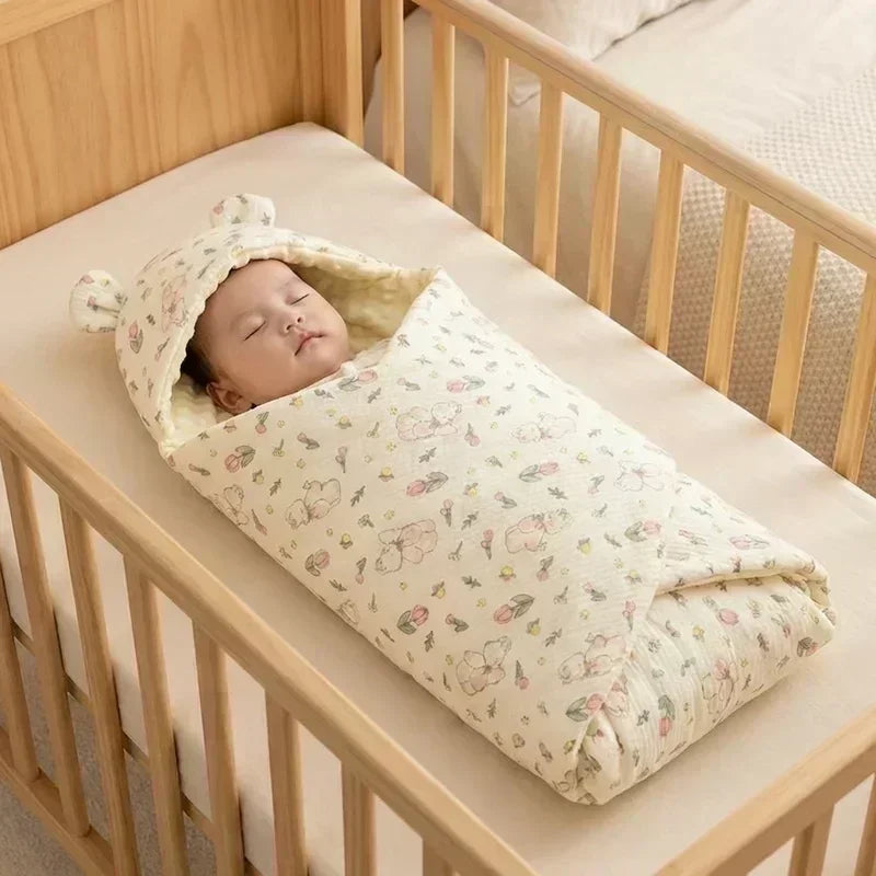 bébé dans un nid d’ange léger motif floral ourson, dans un berceau en bois clair.