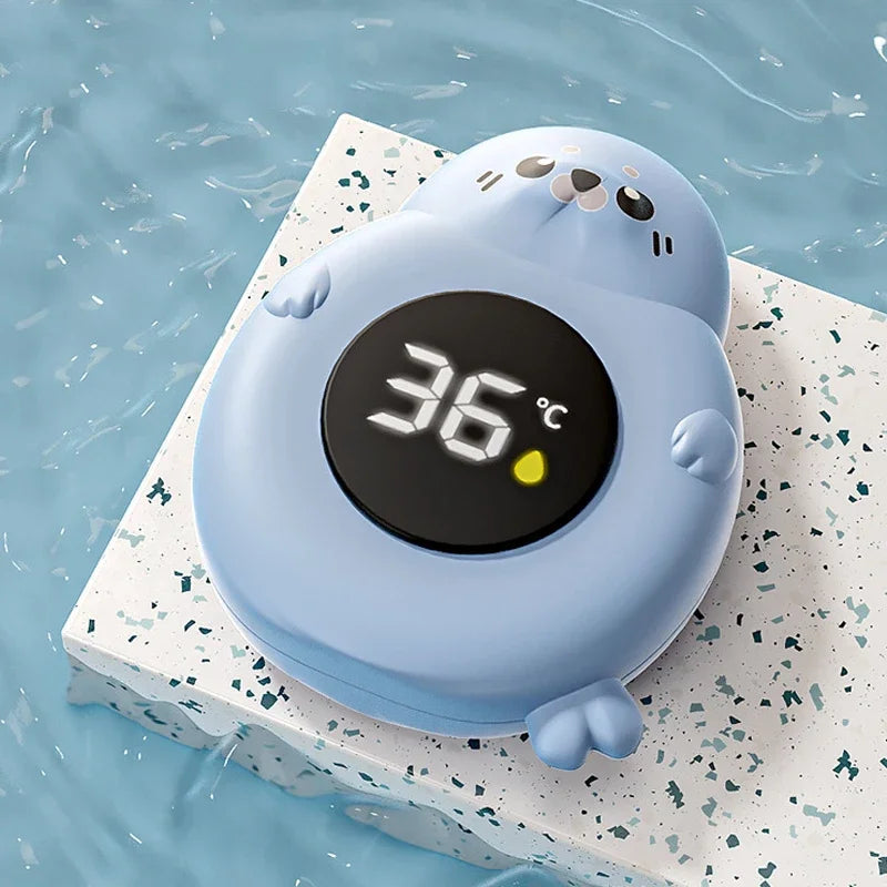 Thermomètre de bain bébé digital flottant en forme de phoque bleu, affichant 36°C.